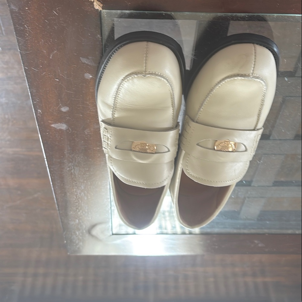 Cream Loafers with Moccasin Toe and Decorative Strap.The brand is Beau Today.